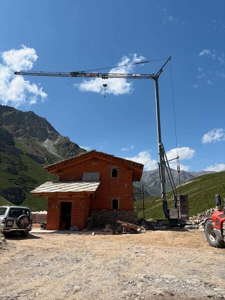 image by anonymous containing tractor, building, house, crane, mountain