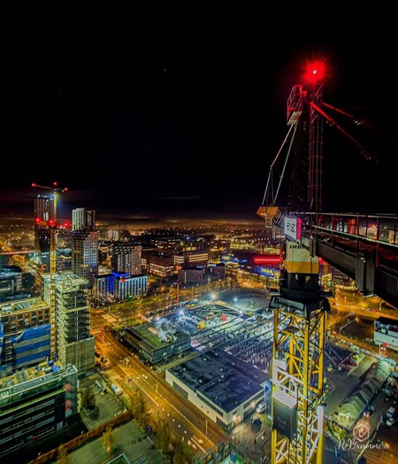 image by anonymous containing city, night, building, crane, tower
